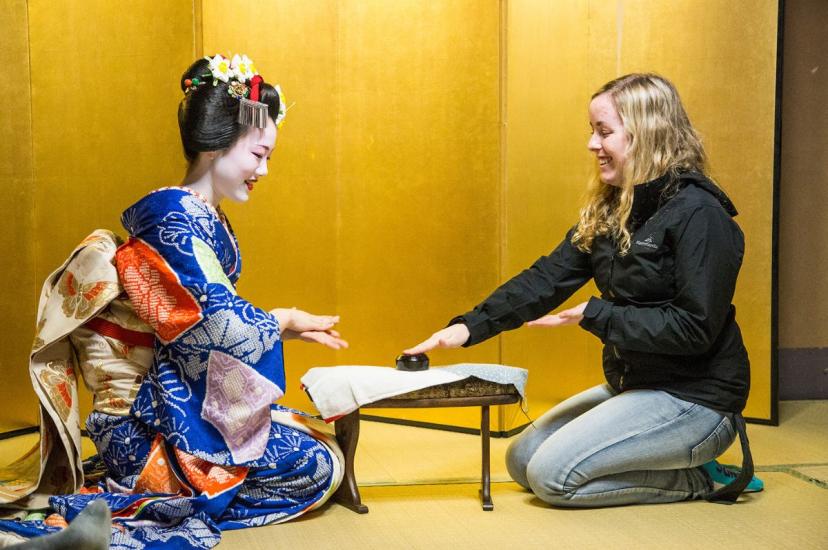 A woman and maiko sitting together smiling