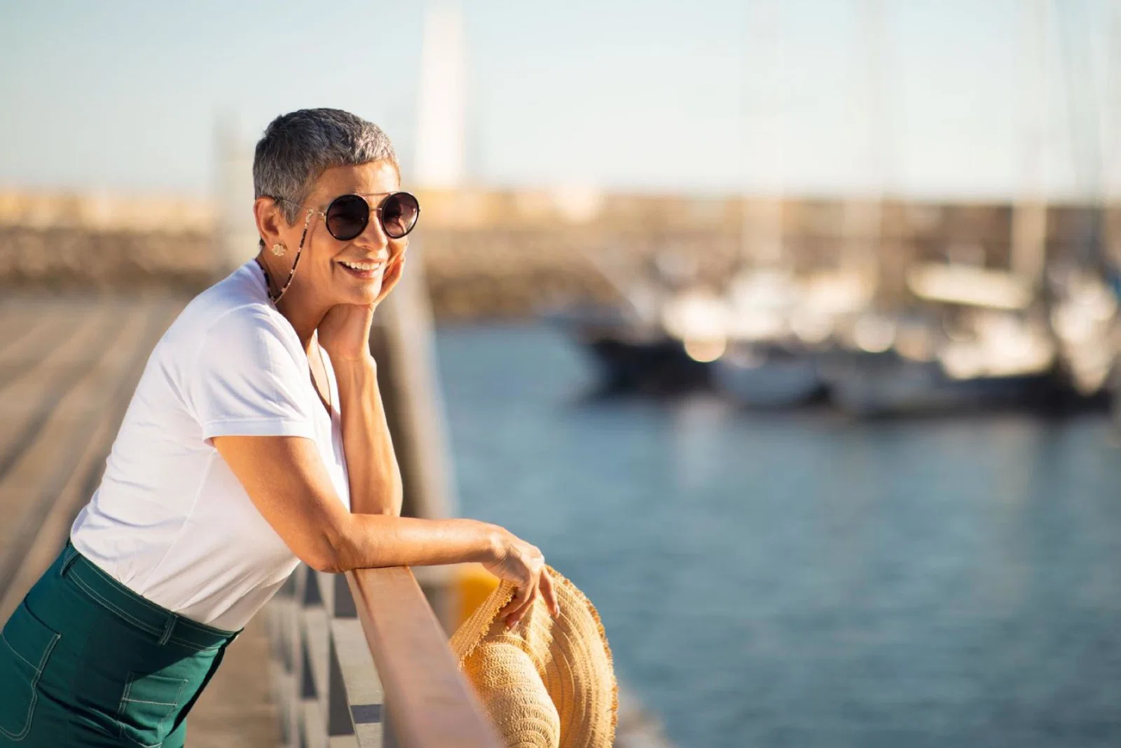 A female solo travellers looks out to sea from a harbour