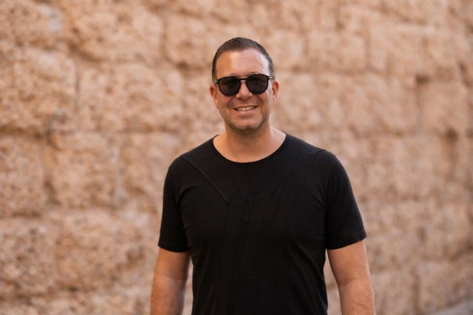 Smiling man in black t-shirt and black sunglasses 