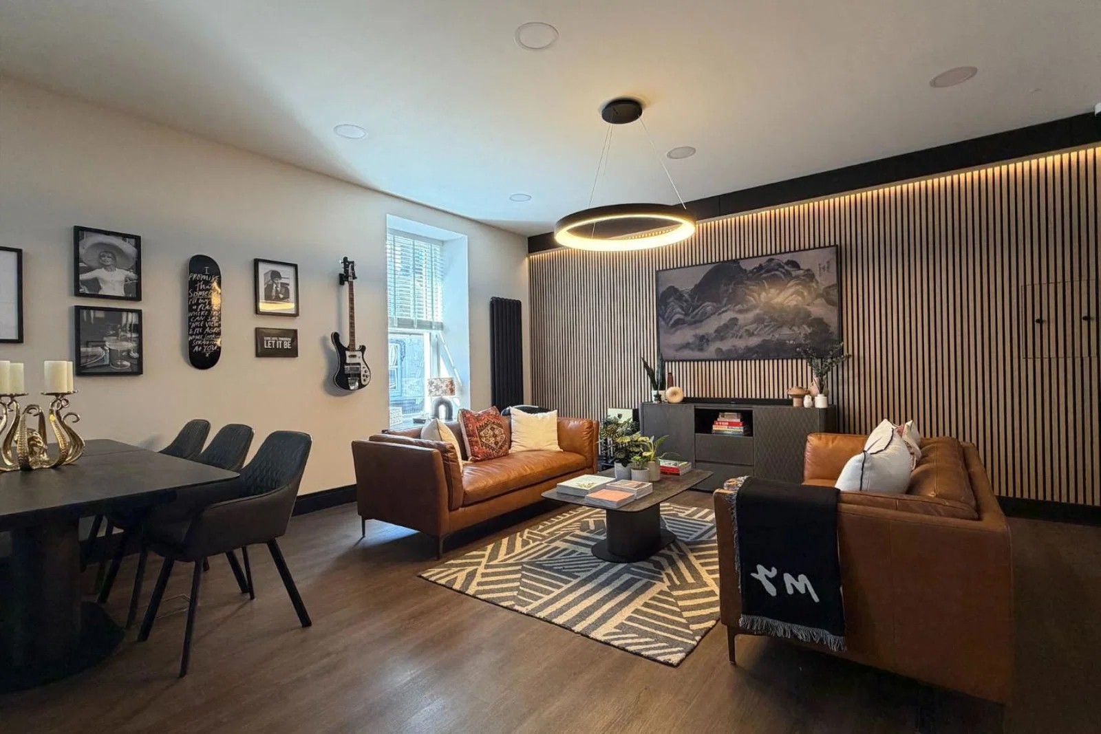 Cozy sitting room with brown couches and wooden dining set 