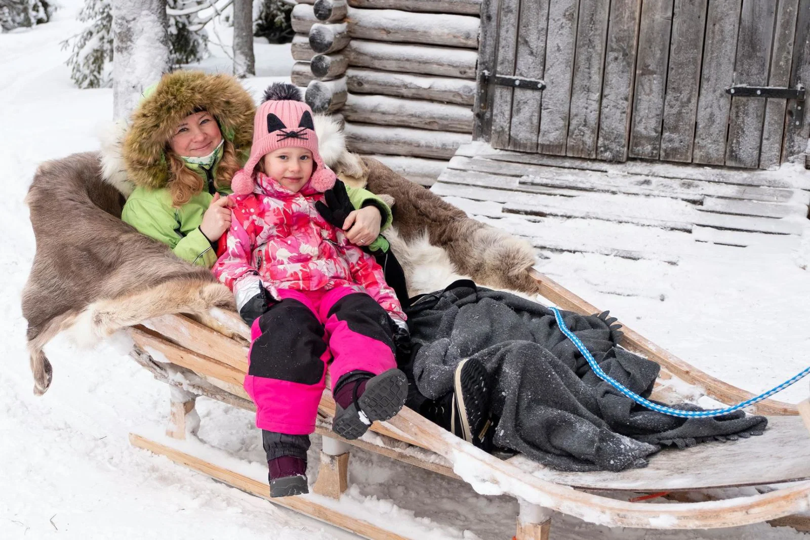 A family enjoy a sleigh ride in Lapland