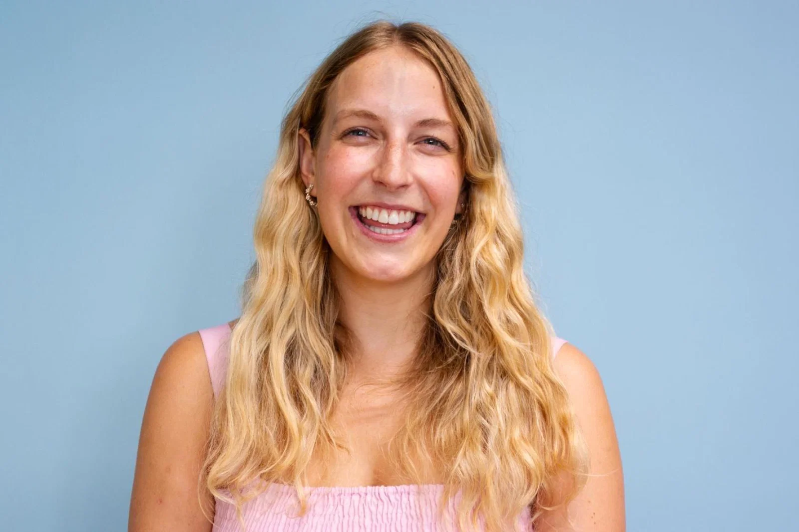 Young white woman with long wavy blonde hair smiling at camera 