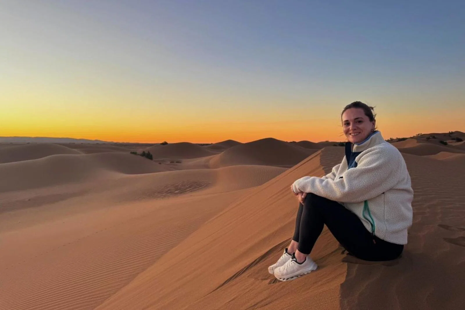 Travel agent Vanessa Good sitting on Sahara sands at sunrise