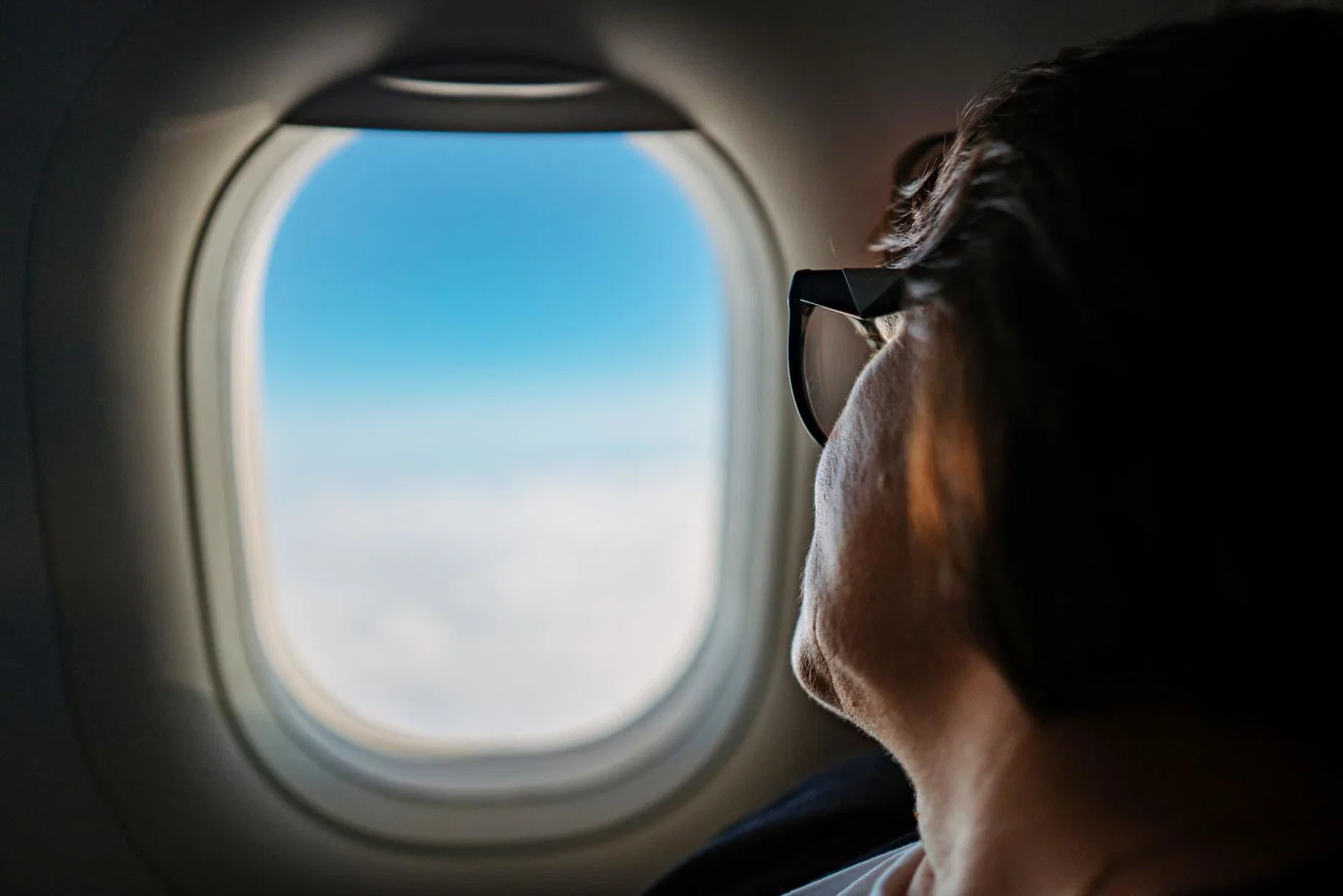A passenger looks out the window of an aircraft