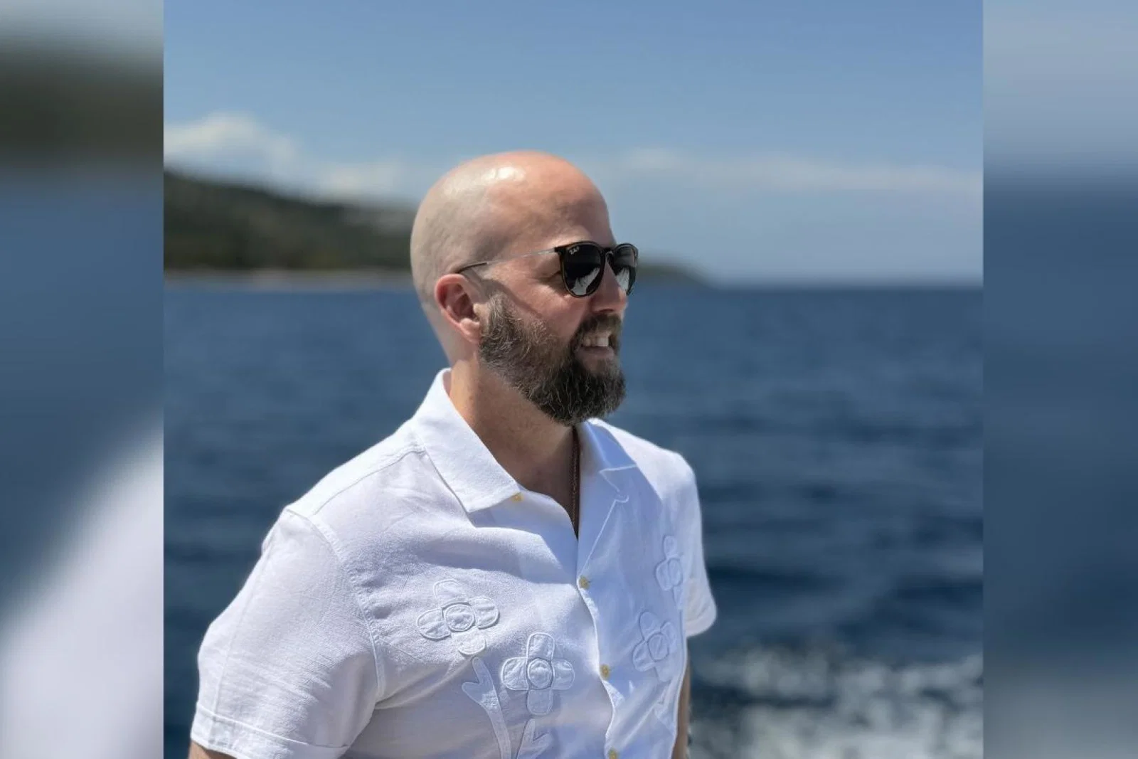Man with sunglasses looking out to sea 