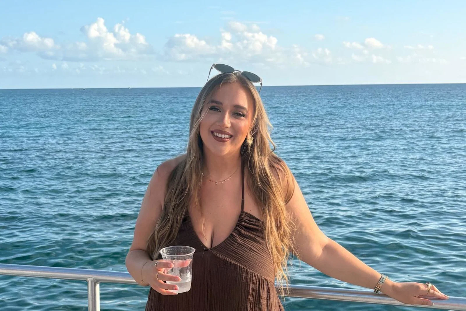 Smiling young woman with long brown hair and marine background 