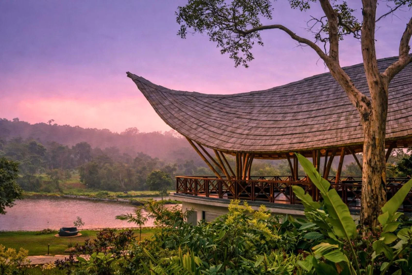 Curved roof villa terrace overlooking peaceful lake with pink sky 