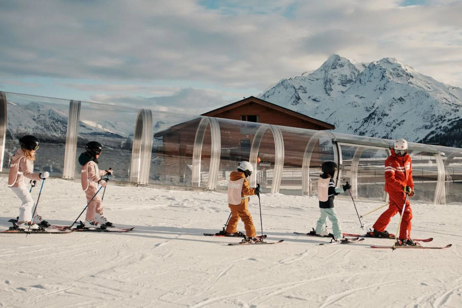 children on skis following an instructor