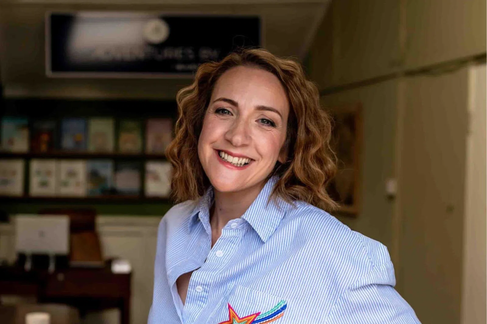 Smiling white woman with chin-length brown hair and blue striped shirt