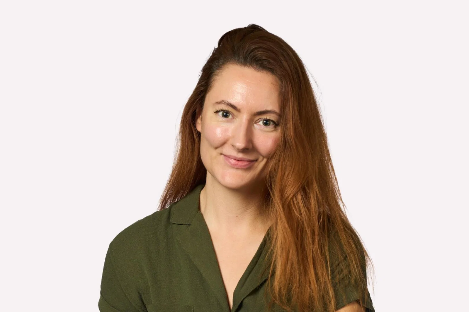 Professional head shot of young white woman with long red hair and green dress 