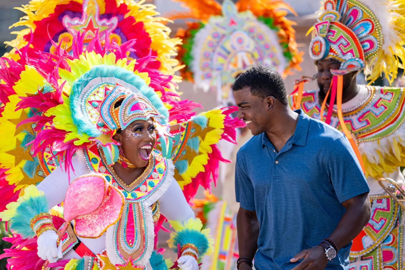 Woman wearing elaborate and colourful costume and local tourist smiling at each other