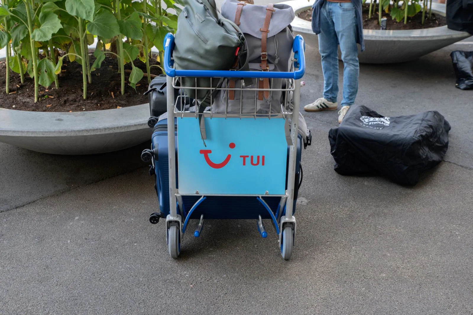 An airport luggage trolley featuring the Tui logo