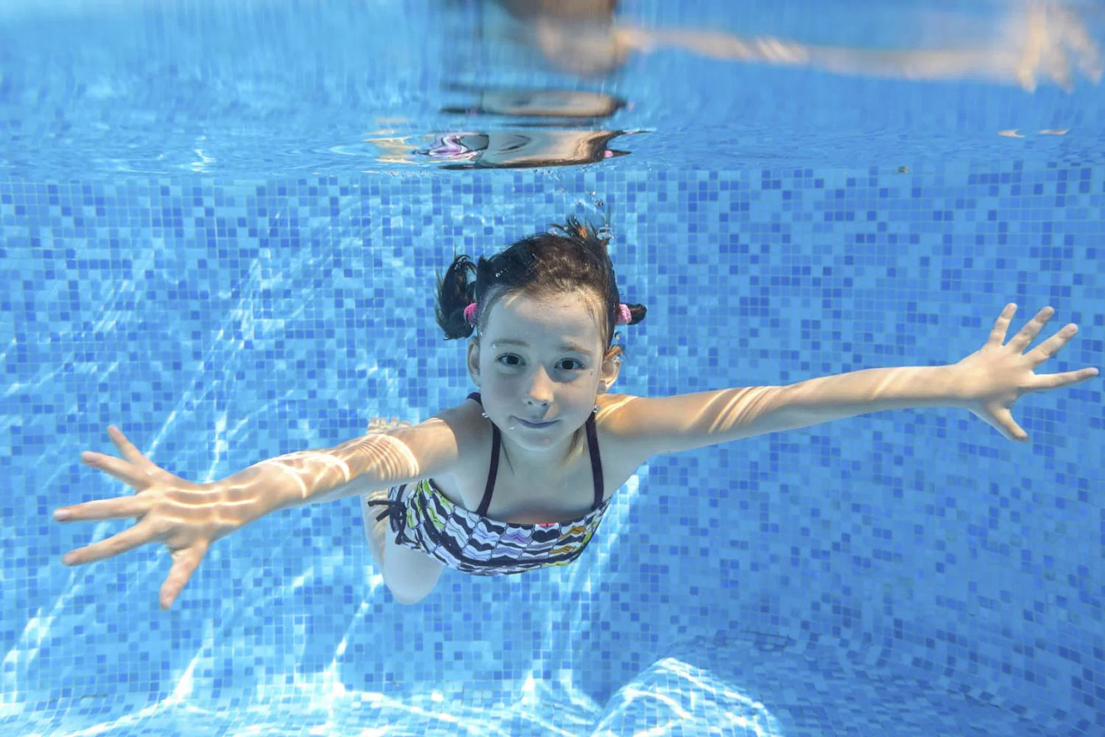 Family holiday - girl swimming (stock)
