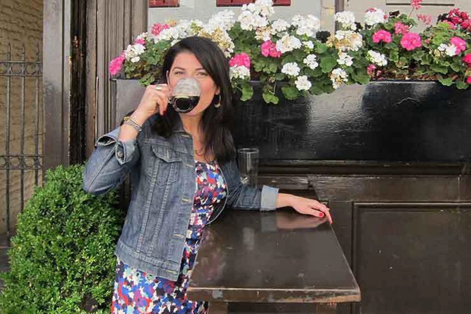 Lady drinking half a pint of bitter outside a pub
