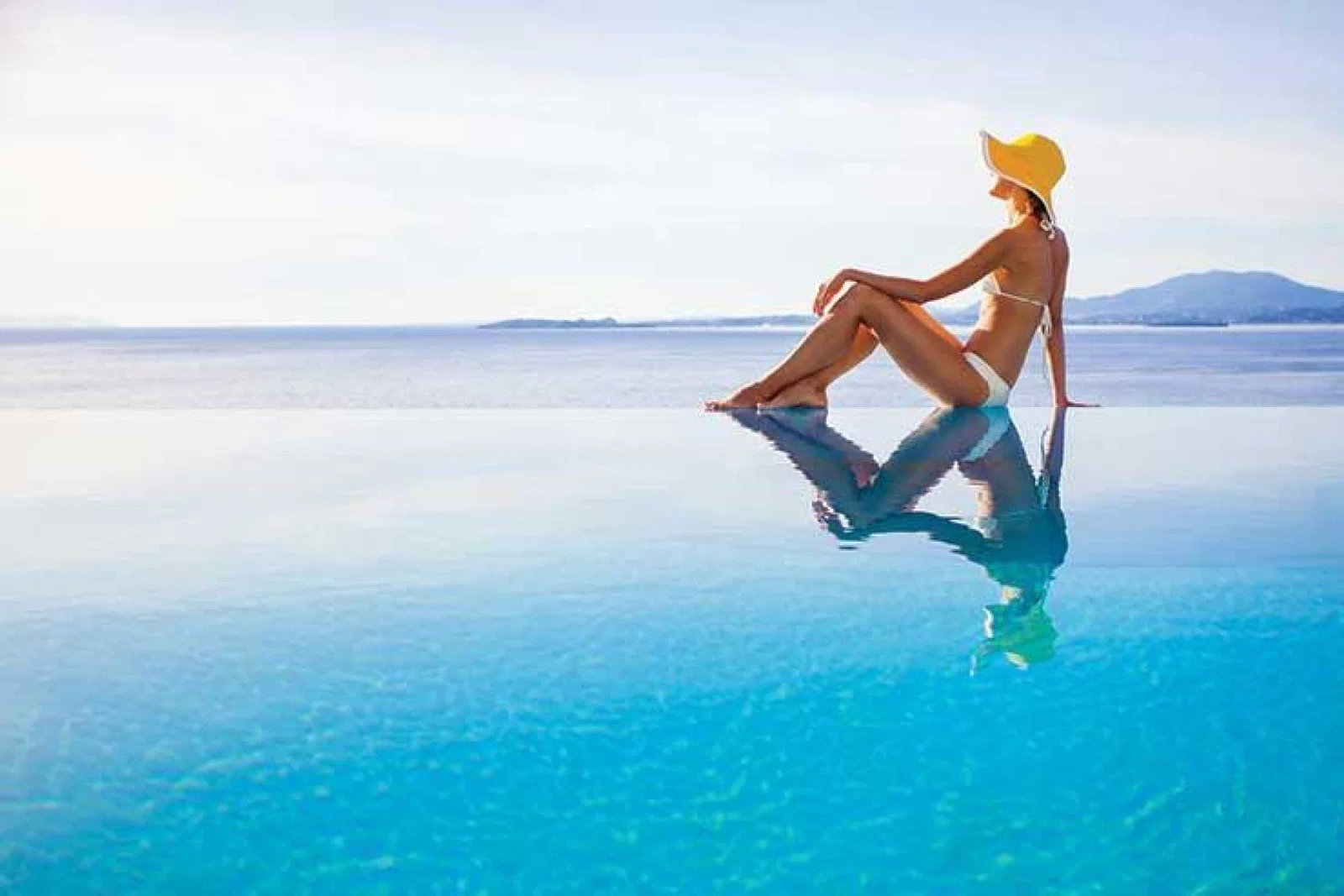 Lady sitting in infinity pool iStock-496069702