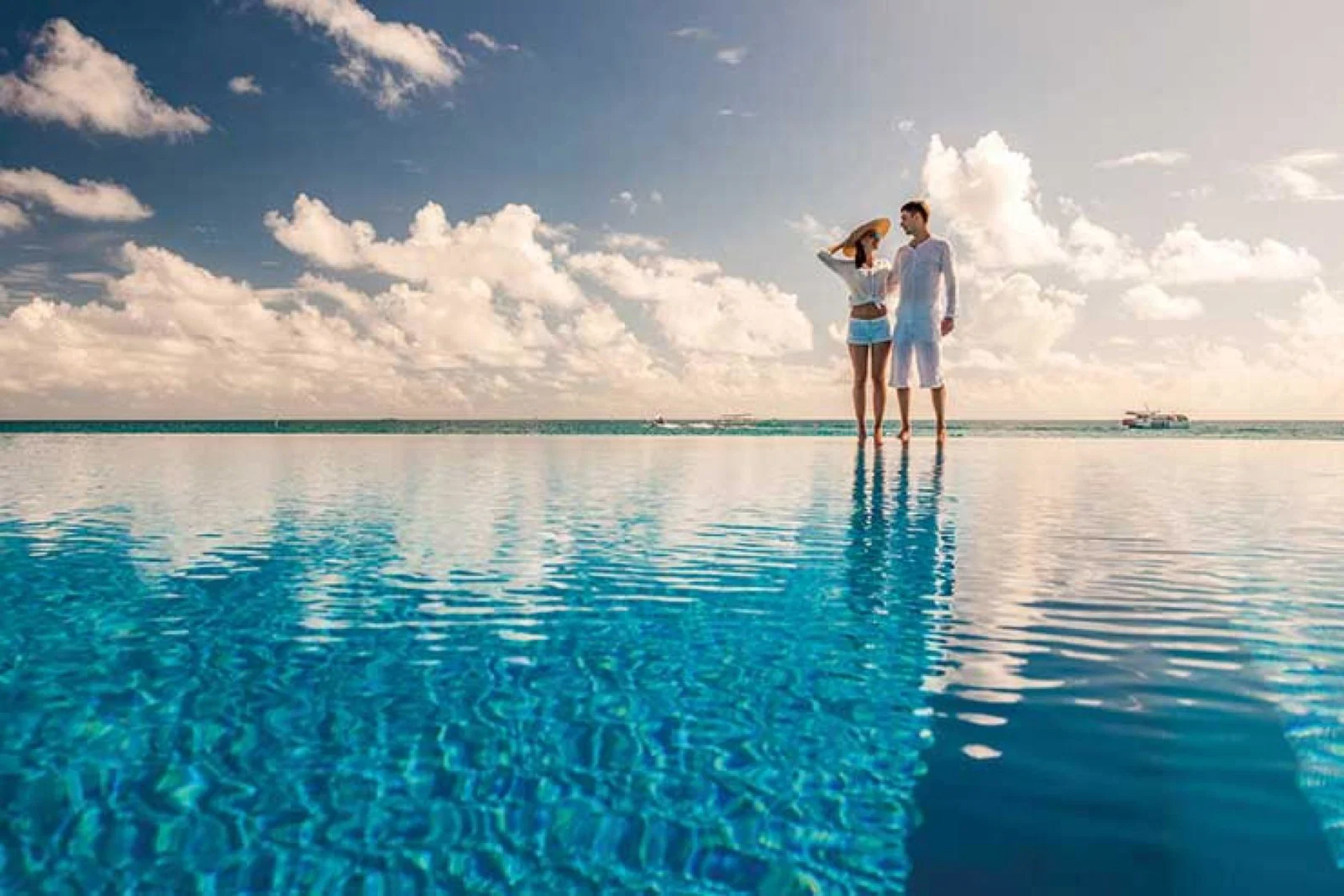 Couple standing by infinity pool