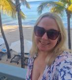 Blonde woman with sunglasses smiling in tropical location   