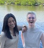 Two women smiling in front of water 