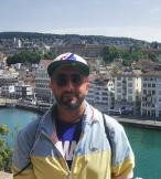 Man with sunglasses and hat in front of river in Europe