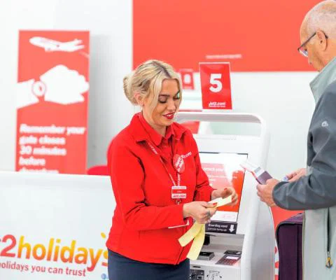 A member of Jet2 check-in staff assisting a passenger