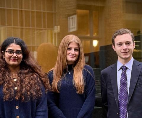 Three young people, two women and one man, dressed smartly 