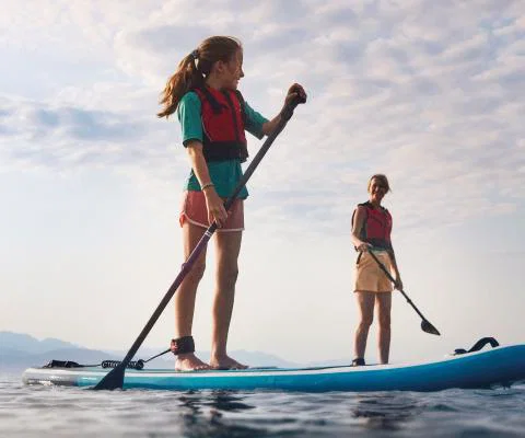 Two people standing on paddleboards 