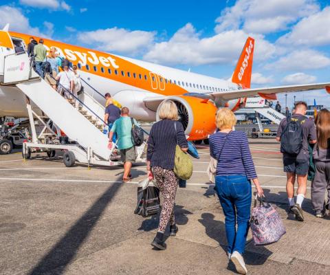 Easyjet customers climbing onto plane on sunny day