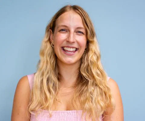 Young white woman with long wavy blonde hair smiling at camera 