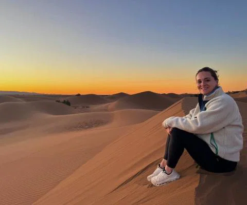 Travel agent Vanessa Good sitting on Sahara sands at sunrise