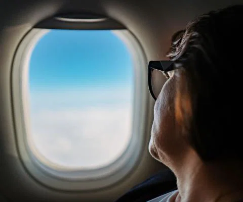 A passenger looks out the window of an aircraft