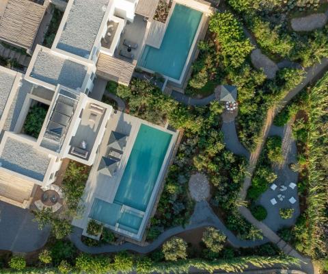 Votsalakia Seaside Escape birds eye view of the villas showcasing greenery surrounding the villa complex, pools and courtyards