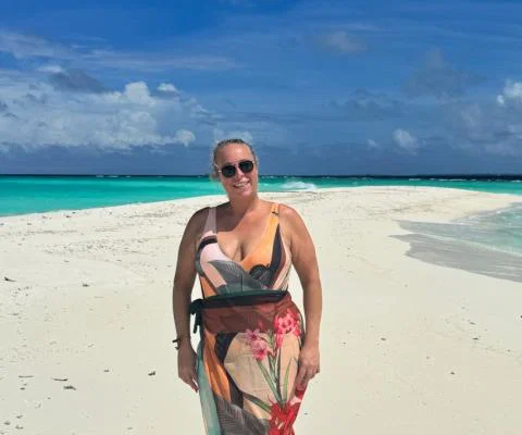 White woman smiling on sandy beach in the Maldives 