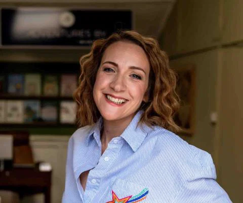 Smiling white woman with chin-length brown hair and blue striped shirt
