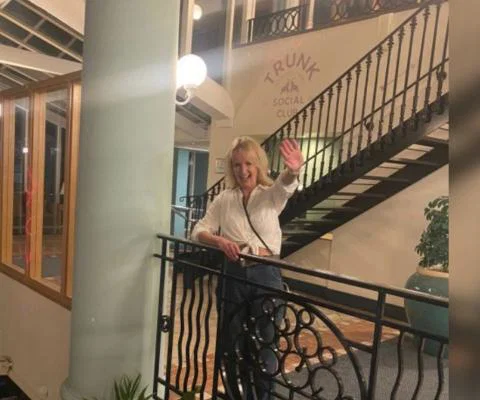 Woman with blonde hair smiling by balcony
