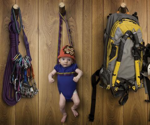 Adventure concept - baby with rock climbing gear (stock)