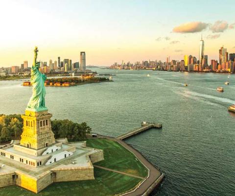 Statue of Liberty, Manhattan background iStock-608615480