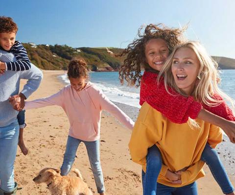Parents-Giving-Children-Piggybacks-As-They-Walk-Along-Winter.jpg