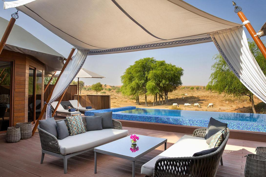 (credit: RAKTDA) Sofa and chairs on a wooden patio with small pool and desert in background