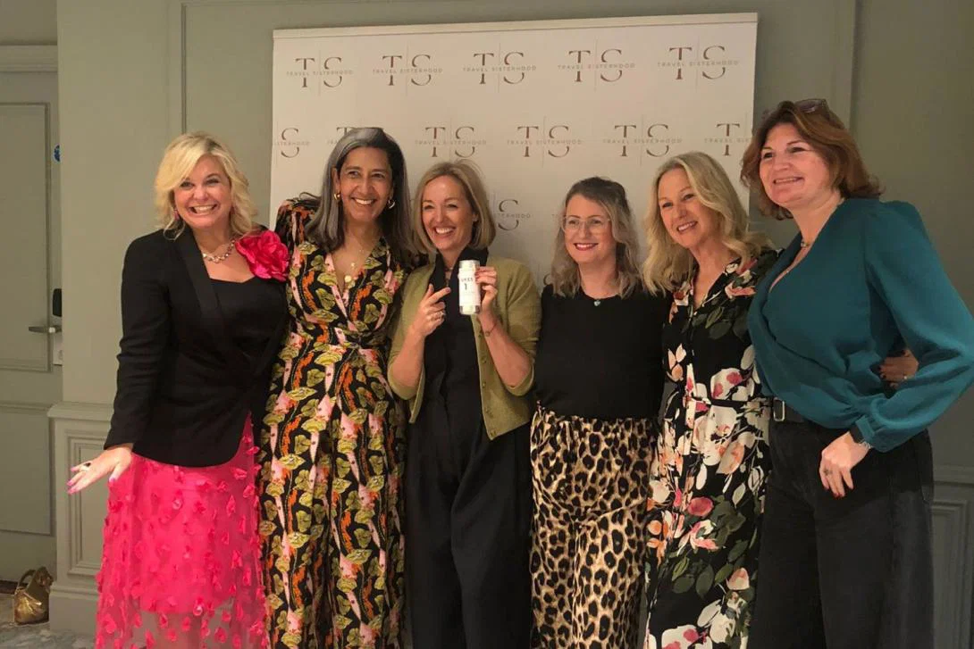 Six women smiling at formal event