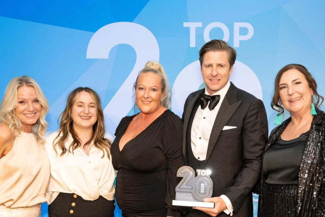 Four women, one man, holding a trophy at a fancy event