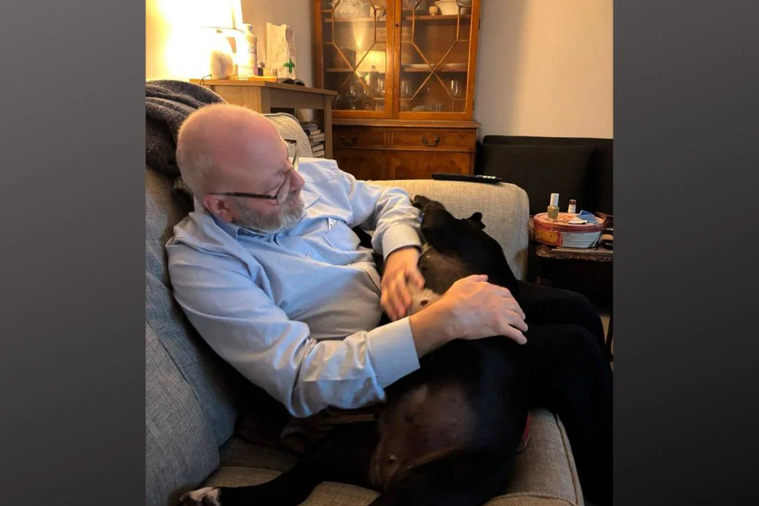 Older man sitting on coach with his dog
