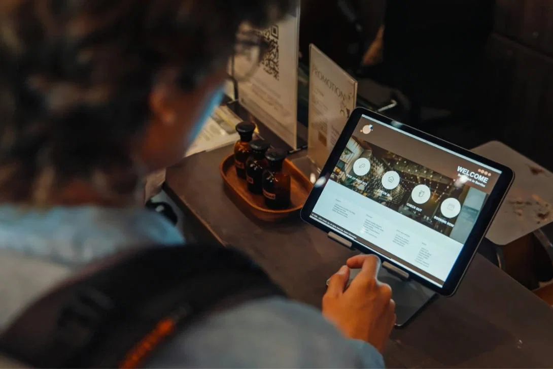 Person using touchscreen tablet to check into hotel