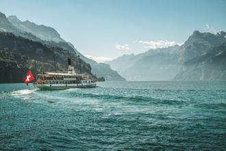 Passenger ferry travelling across Switzerland lake with mountains surrounding
