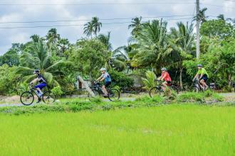 People cycling through luscious Sri Lankan countryside