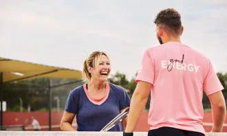 Woman laughing with tennis racket in hand